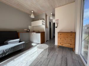 ソポトにあるSopot 34 przy plażyのリビングルーム(ベッド1台、テーブル付)、キッチンが備わります。