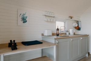 a kitchen with white cabinets and a counter top at Strathy Bay Pods in Strathy