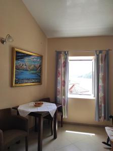 ein Wohnzimmer mit einem Tisch und einem Fenster in der Unterkunft Gudelj Apartments in Perast