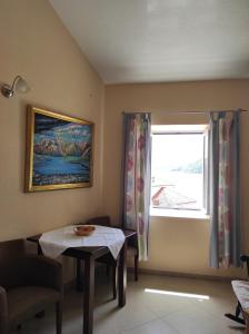 a living room with a table and a window at Gudelj Apartments in Perast