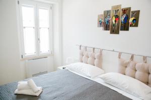 een witte slaapkamer met een groot bed met witte kussens bij Kennedy 54 in Alghero