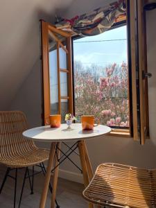 a table and two chairs in front of a window at Mulleys Cottage (Bed and Breakfast) in Westleton