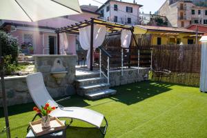 a backyard with a lawn with a staircase and an umbrella at Casa vacanze La Villetta tra Cinque Terre e Versilia in Ameglia