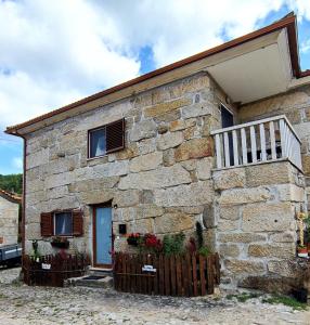 una casa in pietra con una recinzione di fronte di Zimão Garden House a Vila Real