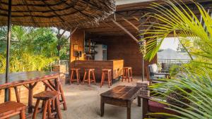 eine Terrasse mit Tischen und Stühlen sowie eine Bar in der Unterkunft Villa Arumeru in Arusha