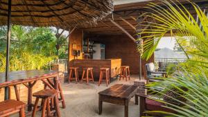 a patio with tables and chairs and a bar at Villa Arumeru in Arusha