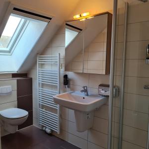 a bathroom with a sink and a toilet at Hotel Restaurant Kastanjehoff in Timmel