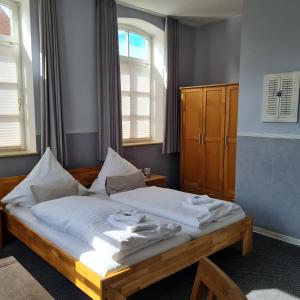 a bedroom with a bed with white sheets and a window at Hotel Restaurant Kastanjehoff in Timmel