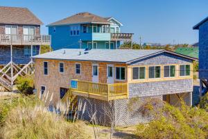 a large house with a balcony on a beach at Walk the Plank 876 in Hatteras