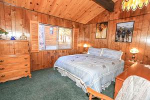 ein Schlafzimmer mit einem Bett und einer Holzwand in der Unterkunft Above it All-1685 by Big Bear Vacations in Big Bear City
