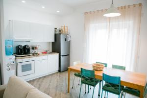 a kitchen with a table and green chairs in a room at Kennedy 54 in Alghero