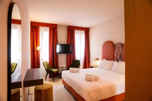 una camera d'albergo con letto e TV di Palazzina Fortuny a Venezia