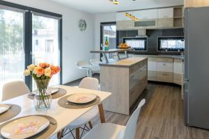 a kitchen with a table and chairs with flowers on it at Casa Blanca Apartman in Balatonfenyves