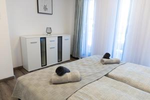 um quarto com uma cama grande com duas almofadas em Casa Blanca Apartman em Balatonfenyves