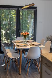 uma mesa com cadeiras e um vaso de flores sobre ela em Casa Blanca Apartman em Balatonfenyves