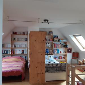una camera con letto e libreria di Idéal Famille à 700m plage - Paddle et vélo inclus a Loctudy
