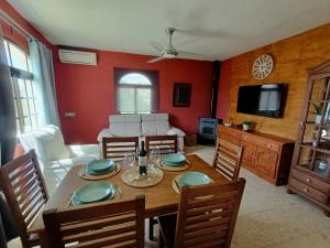 een eetkamer met een tafel met stoelen en een televisie bij Casa Rural Ciudad Soñada in Ronda