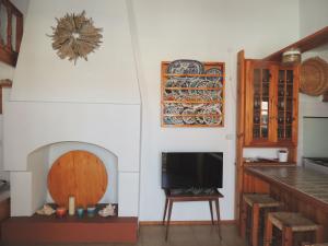 a kitchen with a fireplace and a tv on a wall at Aloustina's House in Symi