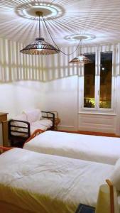 1 dormitorio con 2 camas y 2 luces en Le Cheylard, appartement spacieux et lumineux, en Le Cheylard