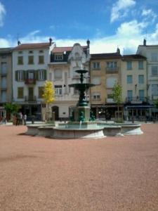 una fuente en un patio frente a un edificio en Le Cheylard, appartement spacieux et lumineux, en Le Cheylard