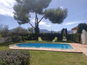 een zwembad in een tuin met een boom bij Casa Rural Ciudad Soñada in Ronda