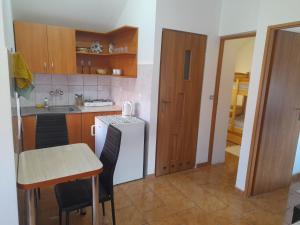 a kitchen with a table and a white refrigerator at Domki u Marcina in Sarbinowo