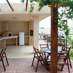 d'une terrasse avec des chaises, une table et un réfrigérateur. dans l'établissement São Luís com conforto e praticidade, à São Luís