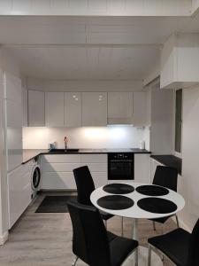 a kitchen with a table and chairs in a room at Alexi Apartments - Newly Renovated Apt in the Heart of the City near to Railway Station and Nokia Arena in Tampere