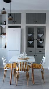 eine Küche mit einem Tisch und Stühlen sowie einem Kühlschrank in der Unterkunft Το σπίτι της Γιαγιάς - Granny's guest's house in Kóronos