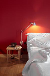 ein Schlafzimmer mit einem Bett und einem Tisch mit einer Lampe in der Unterkunft Casa Camper Berlin in Berlin