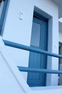 eine blaue Tür an der Seite eines Gebäudes in der Unterkunft Το σπίτι της Γιαγιάς - Granny's guest's house in Kóronos
