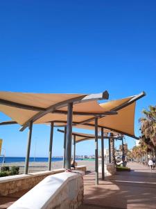 a pavilion on the beach with the ocean in the background at La Rosa Apartment Los Boliches Fuengirola Malaga Spain in Fuengirola