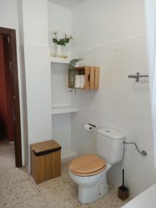 een badkamer met een toilet en een houten stoel bij Casa Rural Ciudad Soñada in Ronda +12 foto's