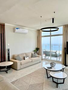 Sala de estar con sofá, mesas y vistas al océano en شقة فاخرة vip مطلة على البحر برج المسارات, en Yeda