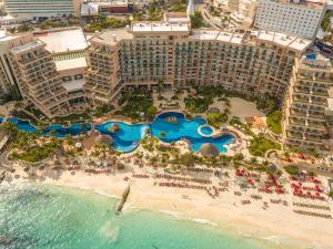 a beach scene with a large building at Grand Fiesta Americana Coral Beach Cancun - All Inclusive in Cancún