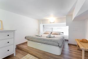 a white bedroom with a bed and a table at Stay U-nique Apartments Travessera II in Barcelona