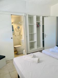 a white room with two beds and a toilet at Can Pep Ramon 2 in Sant Francesc de s'Estany