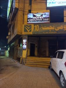 a white car parked in front of a building at Hotel Executive One in Multan