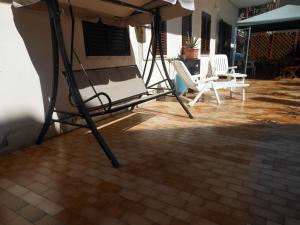 a group of chairs and an umbrella on a patio at Home Patrizia in Acireale