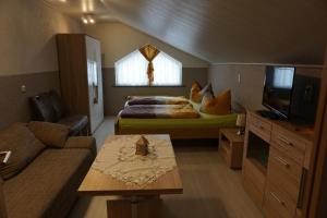 a bedroom with a bed and a couch and a tv at Pension im Glück Thale in Thale
