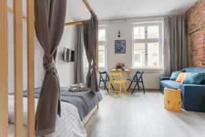a bedroom with a bed and a couch in a room at Simply Modern Apartments in Toruń