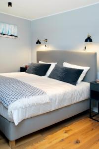une chambre avec un grand lit blanc avec des oreillers noirs dans l'établissement Dream Stay - Superior Apartment in the Heart of Tallinn, à Tallinn