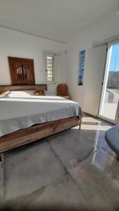 a bedroom with a large bed and a large window at Arion suites Mykonos in Mikonos
