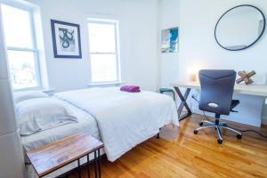 Schlafzimmer mit einem Bett, einem Schreibtisch und einem Stuhl in der Unterkunft 4BR 1,5BH Sunny Apt in Roxbury in Boston