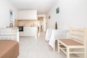 a kitchen with white cabinets and a table in a room at Villa Giorgos in Kefalos