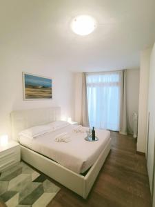 een witte slaapkamer met een groot bed en een raam bij Skyline su San Remo in Sanremo