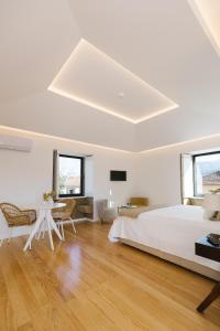 Dormitorio blanco con cama y mesa en Casa Vieira Lobo en Arouca