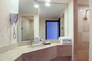 a bathroom with a sink and a mirror at Fiesta Inn Durango in Durango