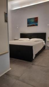 a bedroom with a large bed with a black headboard at Arion suites Mykonos in Mikonos +20 photos