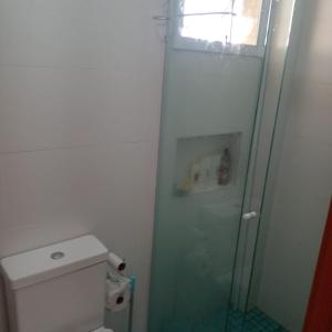 a bathroom with a toilet and a glass shower at Apartamento alto padrão vista mar in Praia Grande